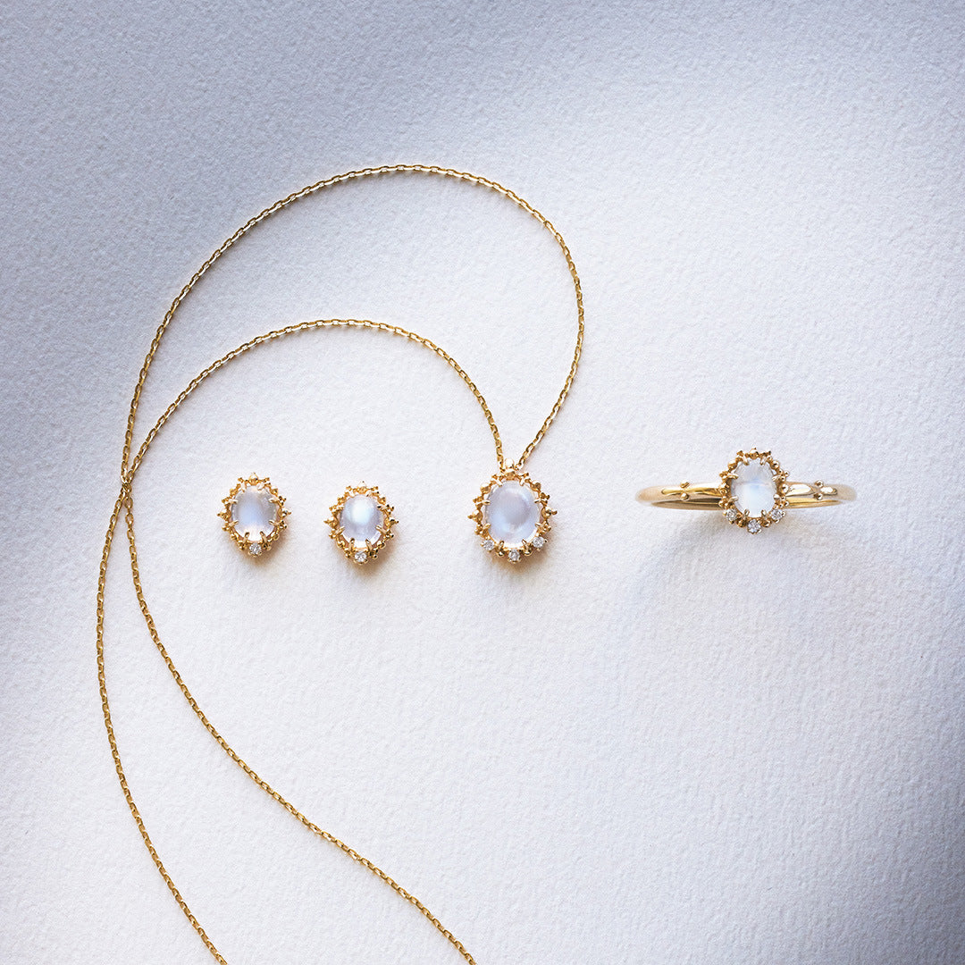 Gold jewelry set with necklace, earrings, and ring on a light gray background