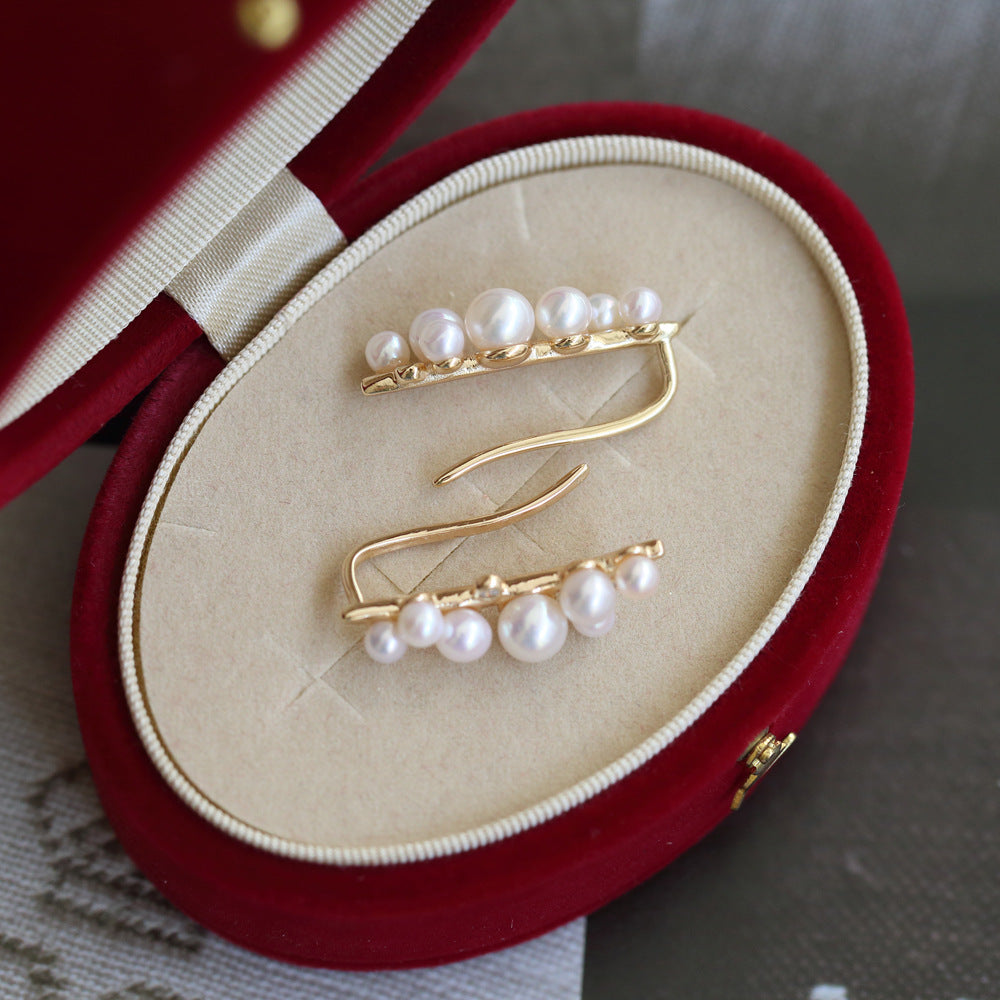 Gold hair clips with pearls on a red jewelry box