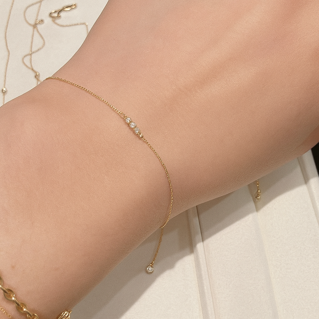Gold bracelet on a person's wrist from The GemBee Jewellery.
