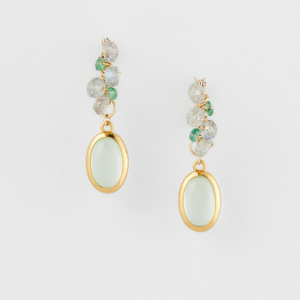 Pair of earrings with green gemstones on a light gray background