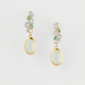 Pair of earrings with green gemstones on a light gray background