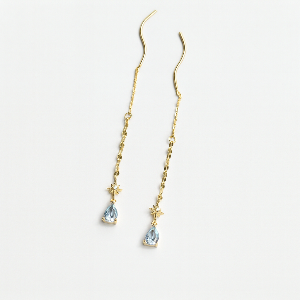 Gold earrings with teardrop-shaped gemstones on a light gray background from Gembee Jewellery