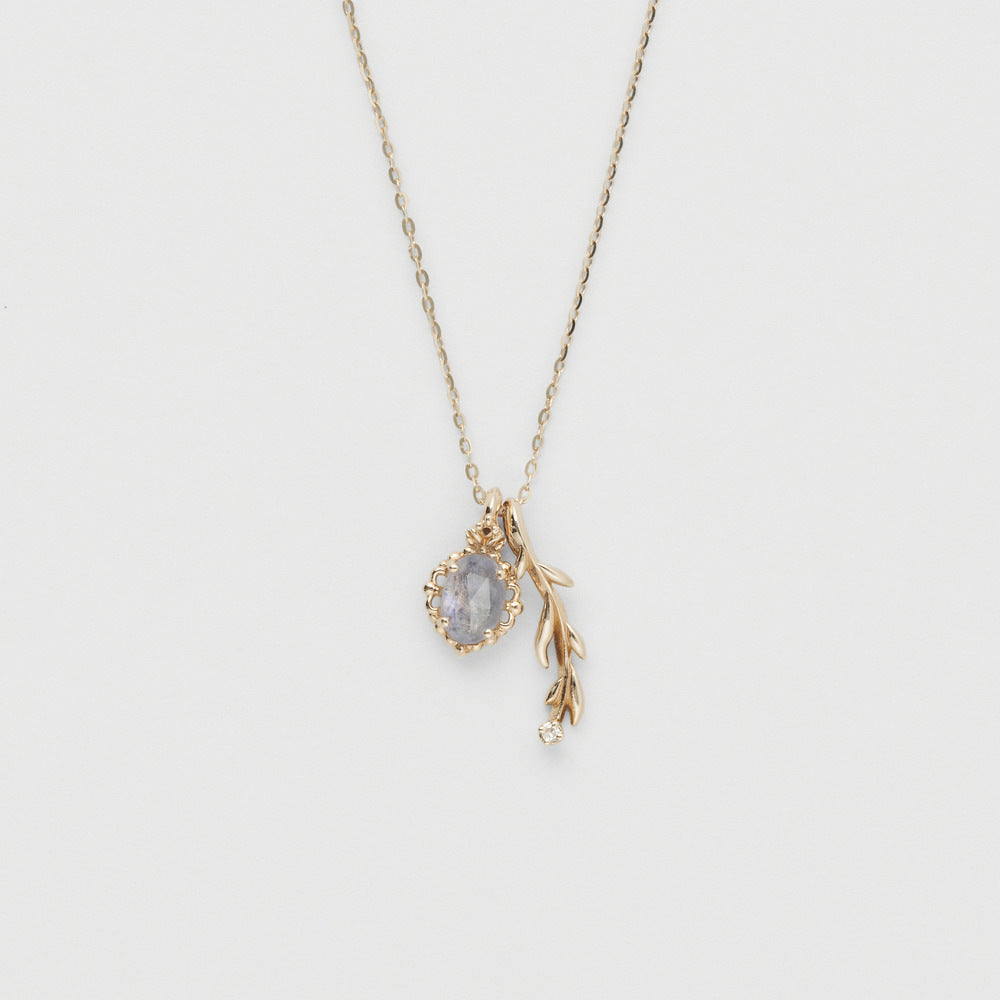Gold necklace with a pendant on a light gray background