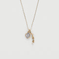 Gold necklace with a pendant on a light gray background