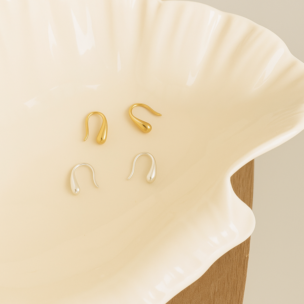 Set of gold and pearl earrings on a beige shell From Gembee Jewellery