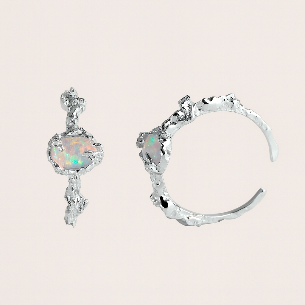 Pair of silver earrings with opal stones on a light pink background from Gembee Jewellery