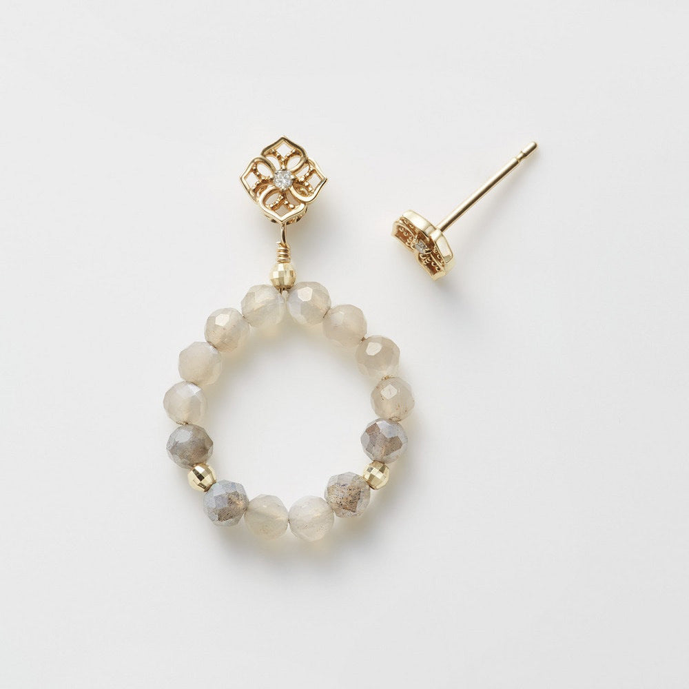 Gold hoop earring with beaded design on a white background