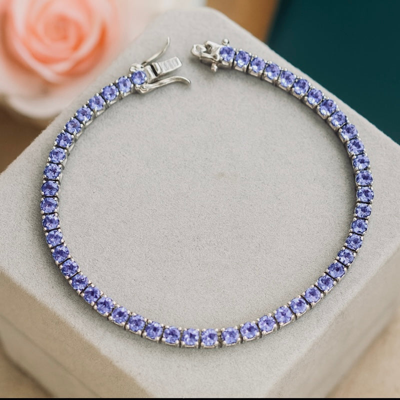 Silver bracelet with blue gemstones on a light gray surface